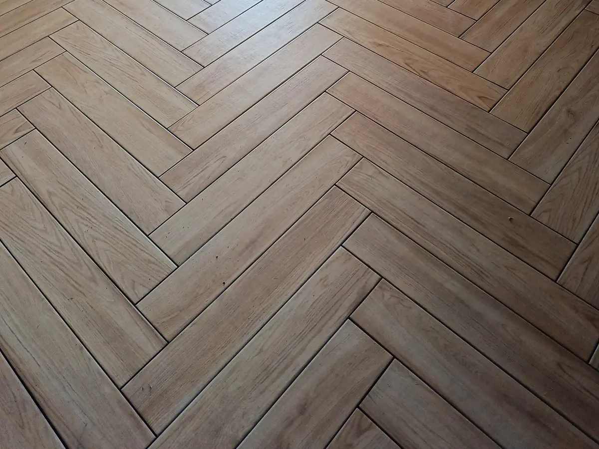 Jasna podłoga ułożona w jodełkę widoczna w przejściu między pomieszczeniami